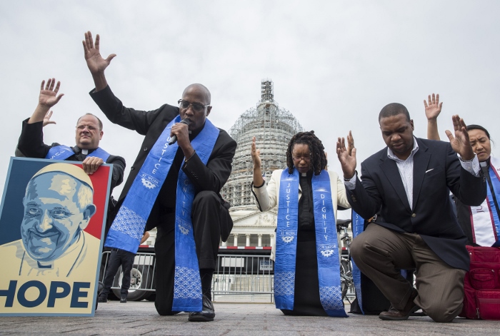 Faith leaders pray as low-wage contract workers from the U.S. Capitol and other federal buildings rally during a strike over wages in Washington Sept. 22. The group invoked the name of Pope Francis as they demonstrated for higher pay ahead of the pontiff's arrival in the nation's capital. (CNS photo/Joshua Roberts)