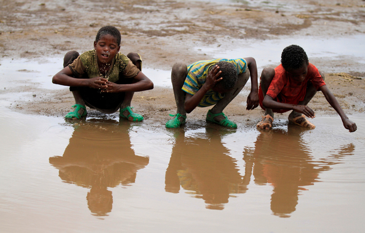 Children wash their heads with rain water in Kobo village, in a drought- stricken area of Ethiopia. (CNS photo/Tiksa Negeri, Reuters)