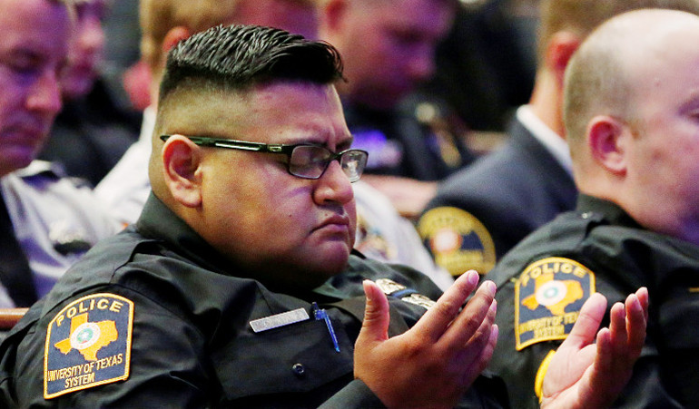 A police officer prays during the July 13 funeral for Dallas police officer Lorne Ahrens, one of five officers fatally shot by a lone gunman. (CNS/Reuters/Carlo Allegri)