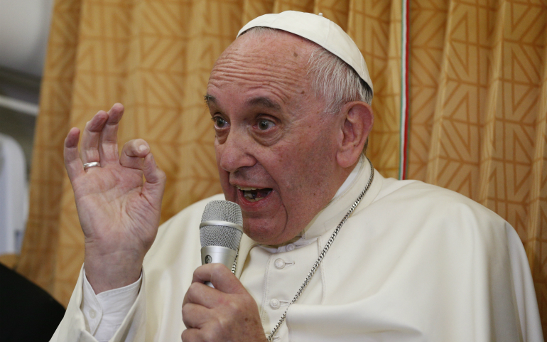 Pope Francis answers questions from journalists aboard his flight from Baku, Azerbaijan, to Rome Oct. 2. (CNS photo/Paul Haring)