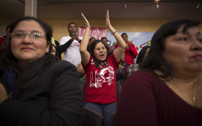 A woman at CASA de Maryland's Multicultural Center in Hyattsville, Md., applauds Thursday after hearing President Barack Obama's national address on immigration. (CNS/Tyler Orsburn)
