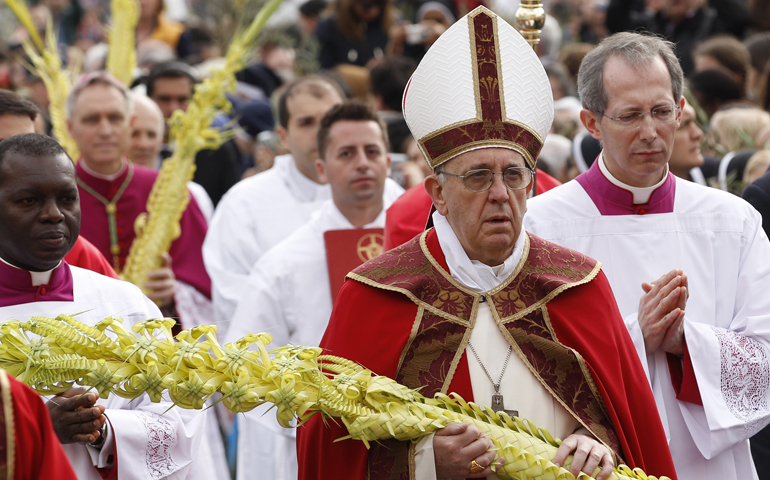 Pope Francis carries woven palm fronds as he walks in procession March 24 at the start of Palm Sunday Mass in St. Peter's Square at the Vatican. (CNS/Paul Haring)