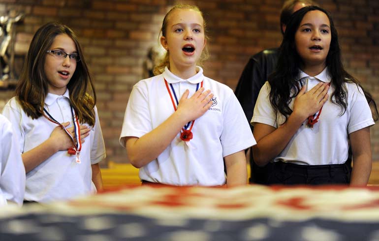Students from St. Rita School recite the Pledge of Allegiance during a Veterans Day service Nov. 8 in Webster, N.Y. Marked officially on Nov. 11, the holiday honors all veterans of the U.S. armed forces. (CNS photo/Mike Crupi, Catholic Courier)