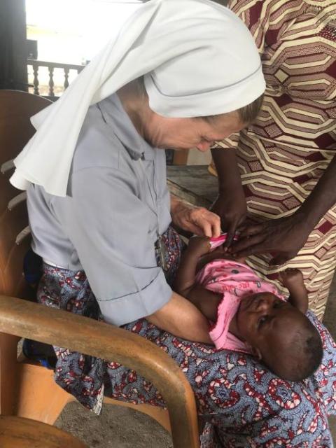 Sr. Monique Bourget examines a baby for malnourishment in Benin. Sr. Monique Bourget examines a baby for malnourishment in Benin.