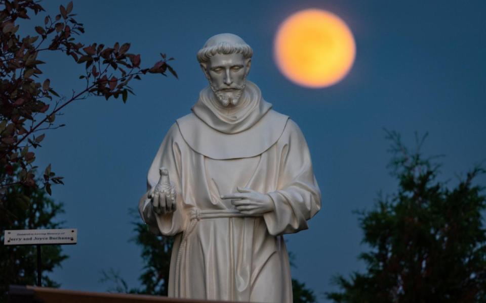 A hunter's moon rises behind a statue of St. Francis of Assisi on the grounds of the National Shrine of Our Lady of Champion in Champion, Wis., Oct 8, 2022 (OSV News/CNS/Sam Lucero)