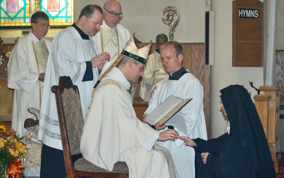 Dom Geoffroy Kemlin, abbot president of the Benedictines' Solesmes Congregation in France, places a ring on the finger of Benedictine Mother Benedict McLaughlin, abbess of Immaculate Heart of Mary Abbey in Westfield, Vermont, during her Nov. 11 abbatial blessing. (OSV News/Vermont Catholic magazine/Cori Fugere Urban)
