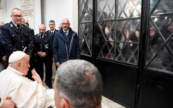 Pope Francis blows a kiss to inmates unable to meet him personally during a Holy Thursday visit to Rome's Regina Coeli jail April 17. 