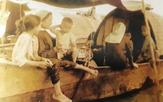 Two Daughters of Our Lady of the Visitation visit people living on a boat in a river in Hue in 1970. (Courtesy photo)
