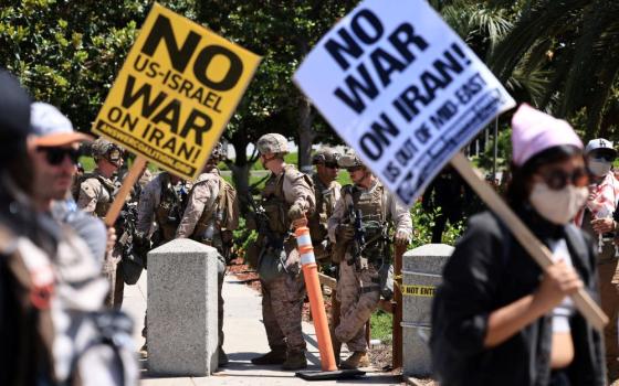 U.S. Marines stand guard as demonstrators protest against the United States joining with Israel in attacks on Iran's nuclear facilities, at a federal building in Los Angeles, Calif., June 22. (OSV News/Reuters/David Swanson)
