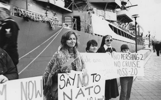 A sister in habit is seen among those holding a vigil against nuclear weapons on the pier alongside the guided-missile destroyer USS Dewey on Nov. 11, 1983. (NCR photo/Peter Wingert)