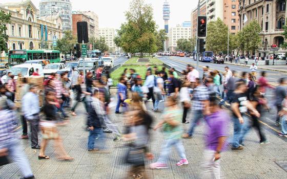 People walking in a busy street intersection (Unsplash/Mauro Mora)