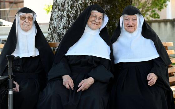 Augustinian Sisters Regina, 86; Rita, 81; and Bernadette, 88, sit on a bench at their old convent in Goldenstein castle in Elsbethen, Austria, near Salzburg Sept. 12. They refuse to return to their retirement home. (OSV News/Reuters/Angelika Warmuth)