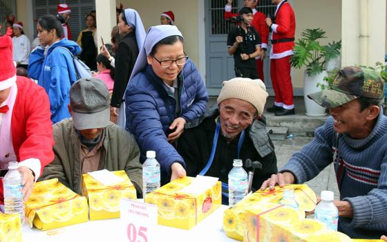 Daughters of Mary of the Immaculate Conception Sr. Mary Teresa Pham Thi Lai (center) distributes Christmas cakes to people affected by natural disasters at her community in Hue, Vietnam, Dec. 23, 2025. (Joachim Pham)