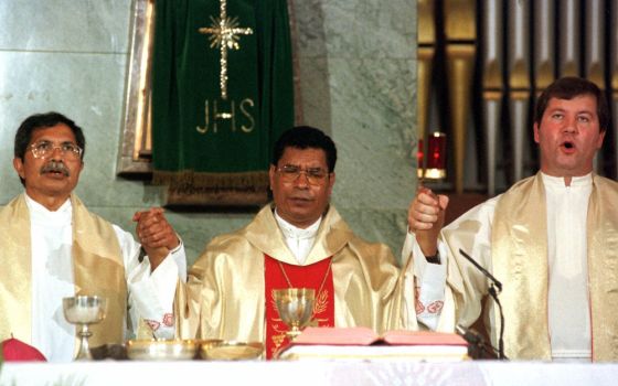 East Timor's Roman Catholic Bishop Carlos Ximenes Belo holds hands with other priests during the Sunday's morning mass at Lisbon's Salesian religious order's church, on Sept. 12, 1999